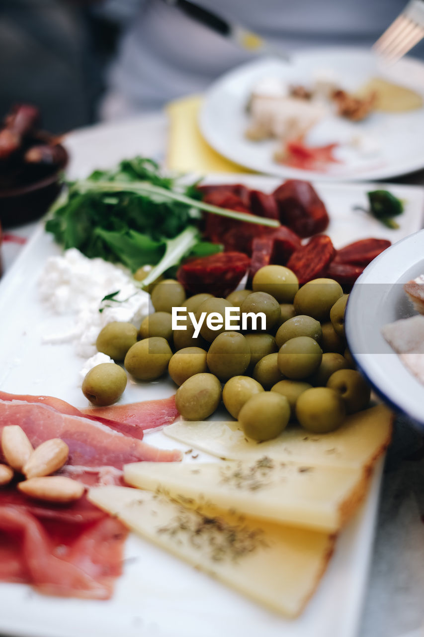 Close-up of tapas on plate, olives, cheese and ham