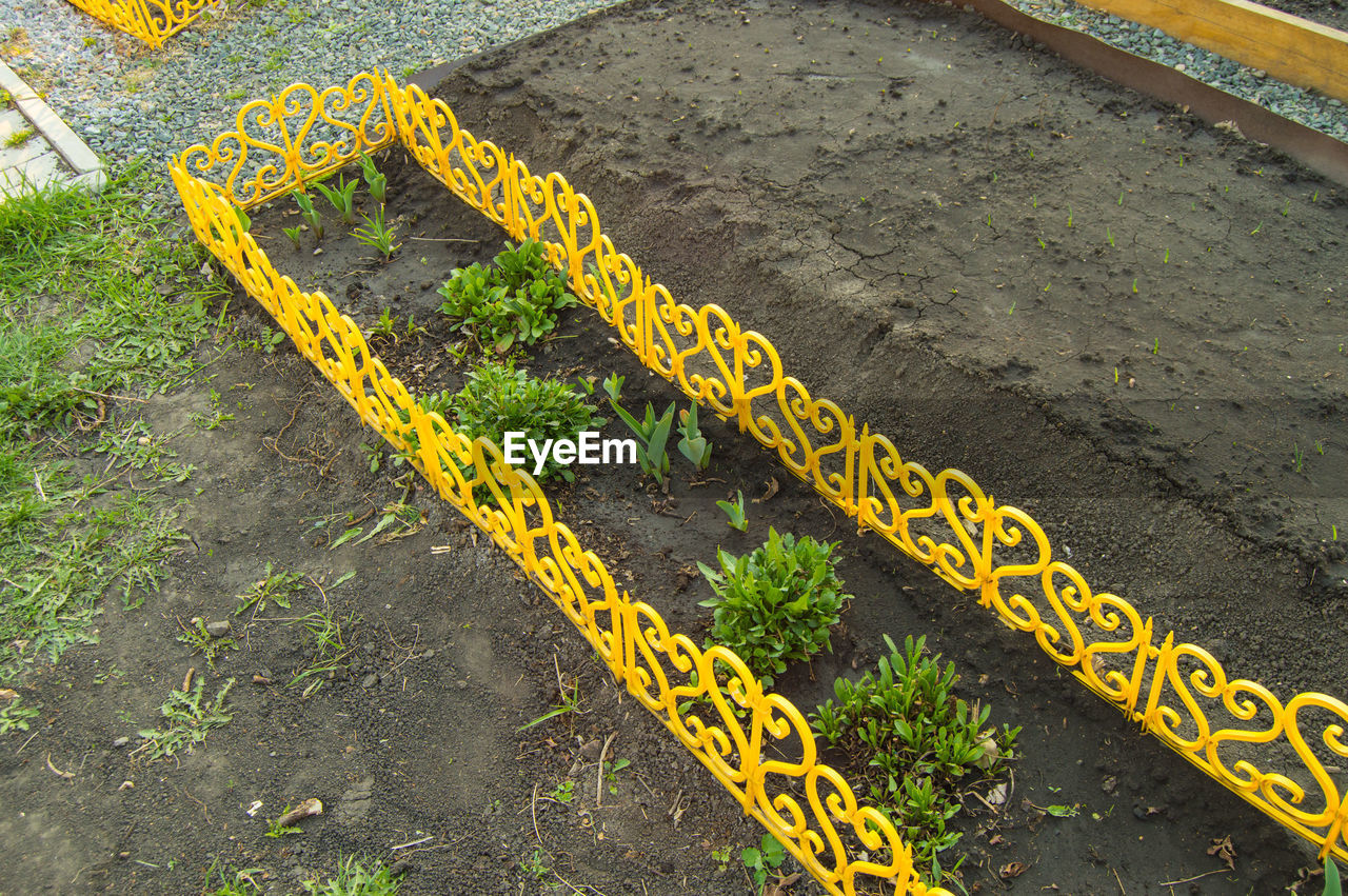 HIGH ANGLE VIEW OF YELLOW TEXT ON CONCRETE ROAD