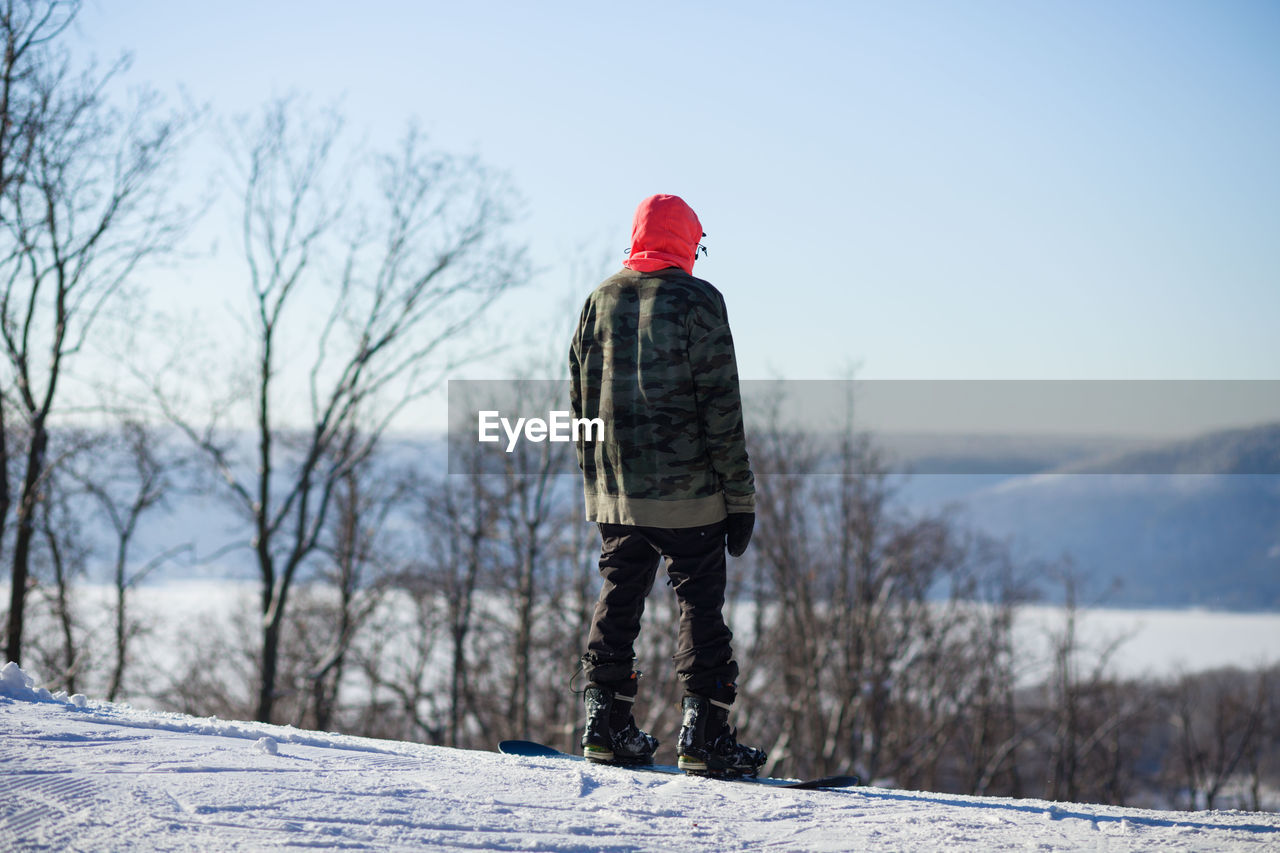 Man snowboarding on land against sky