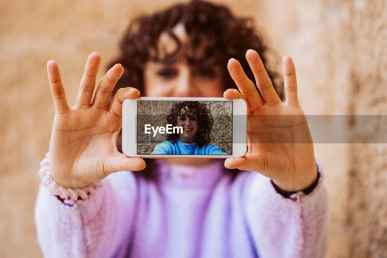 midsection of woman holding mobile phone