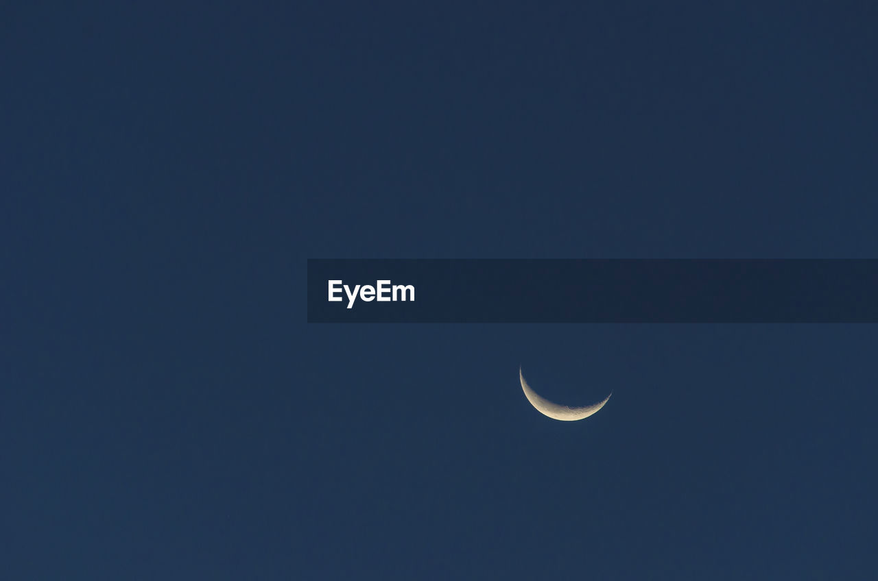 LOW ANGLE VIEW OF MOON IN SKY