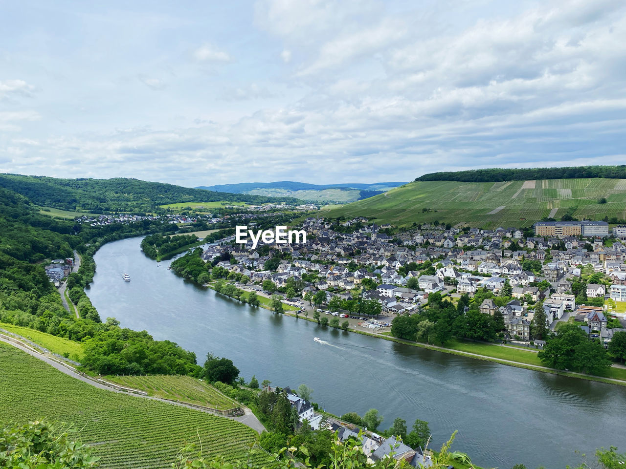 HIGH ANGLE VIEW OF RIVER AMIDST BUILDINGS AGAINST SKY