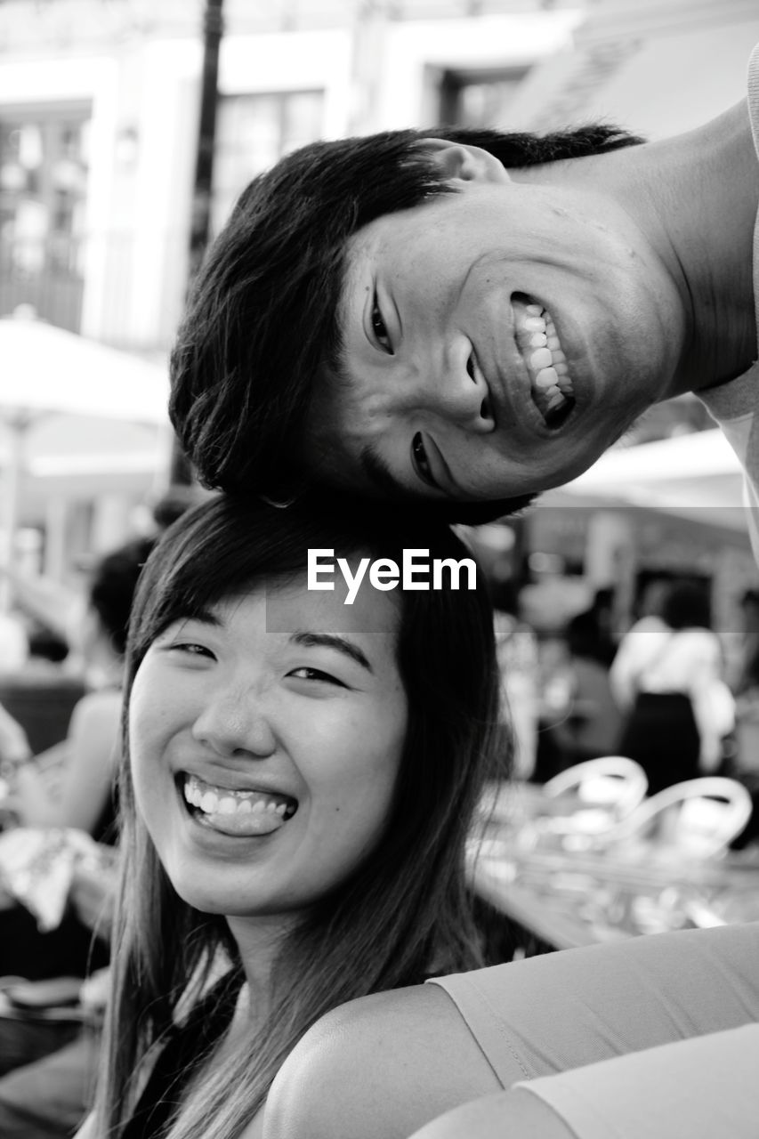 Portrait of cheerful young couple sitting outdoors