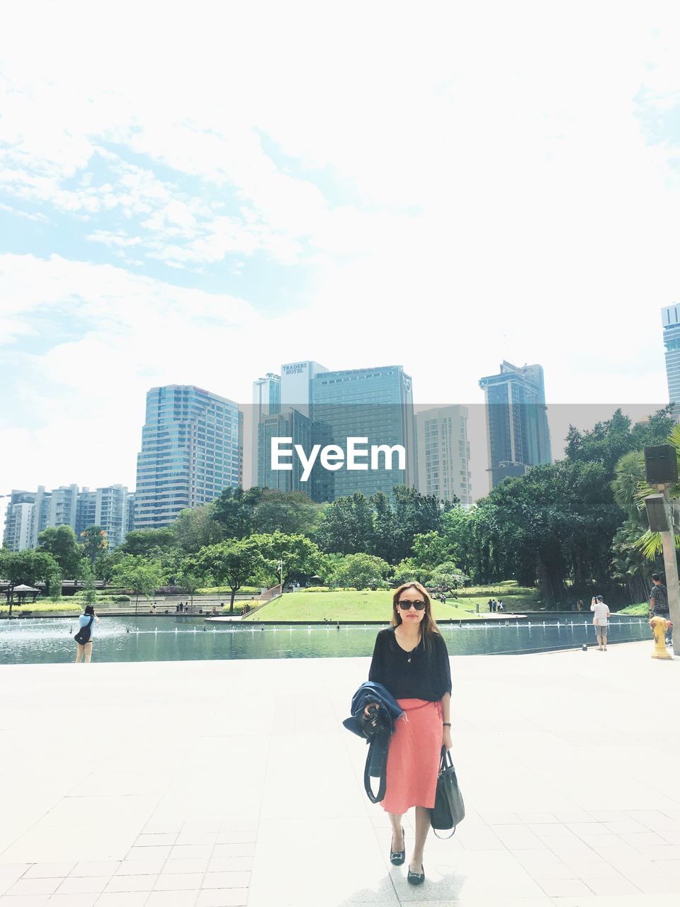 Full length portrait of woman in city against sky