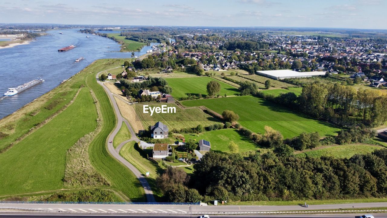 aerial photography, water, bird's-eye view, sea, architecture, high angle view, nature, plant, land, built structure, transportation, landscape, aerial view, city, scenics - nature, environment, building exterior, residential area, coast, road, day, green, tree, sky, beach, building, sports, outdoors, beauty in nature, no people, grass, race track, travel destinations, sport venue, travel, mode of transportation, horizon, field, estate, coastline, cloud, residential district