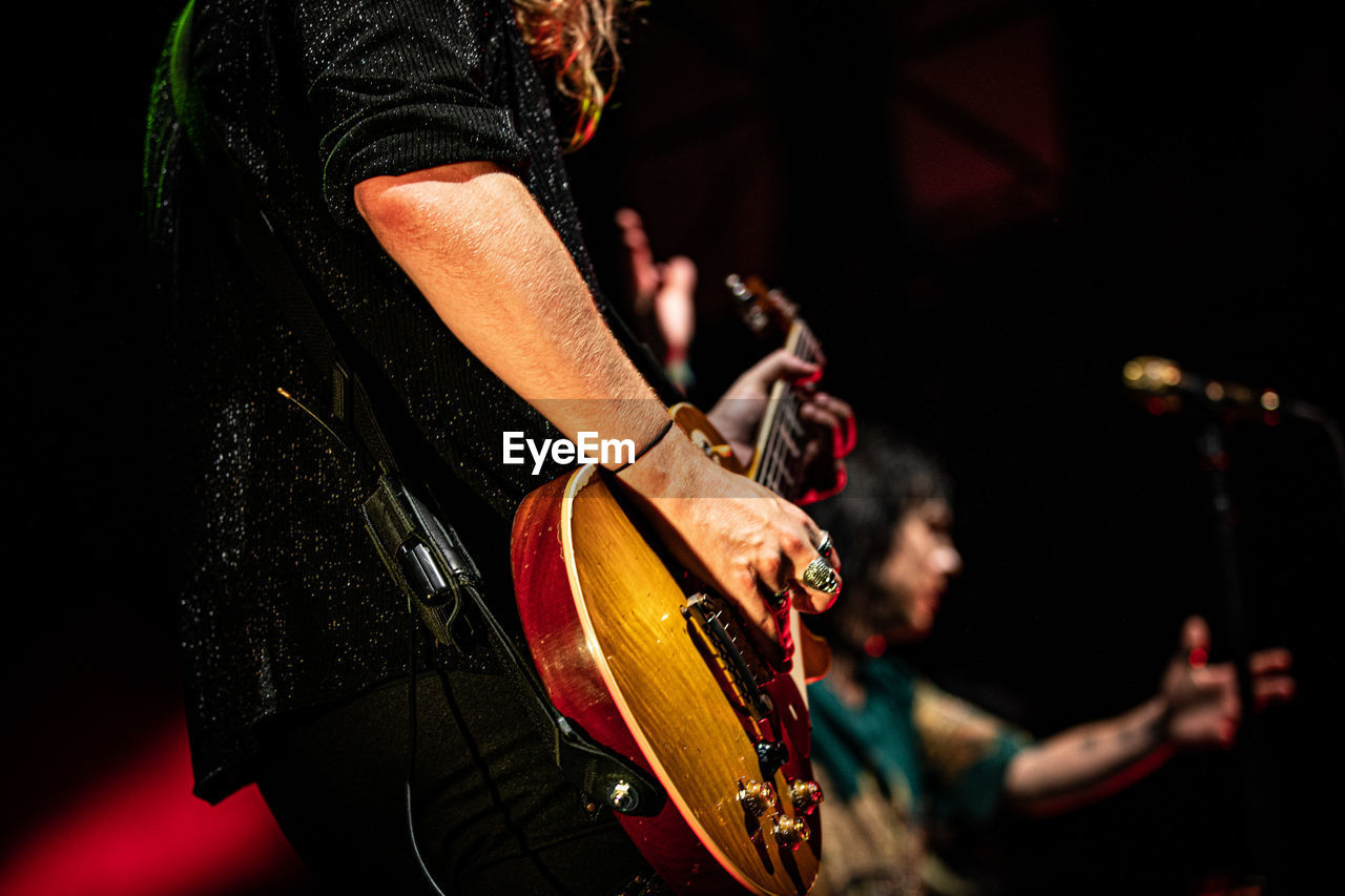 MIDSECTION OF MAN PLAYING GUITAR