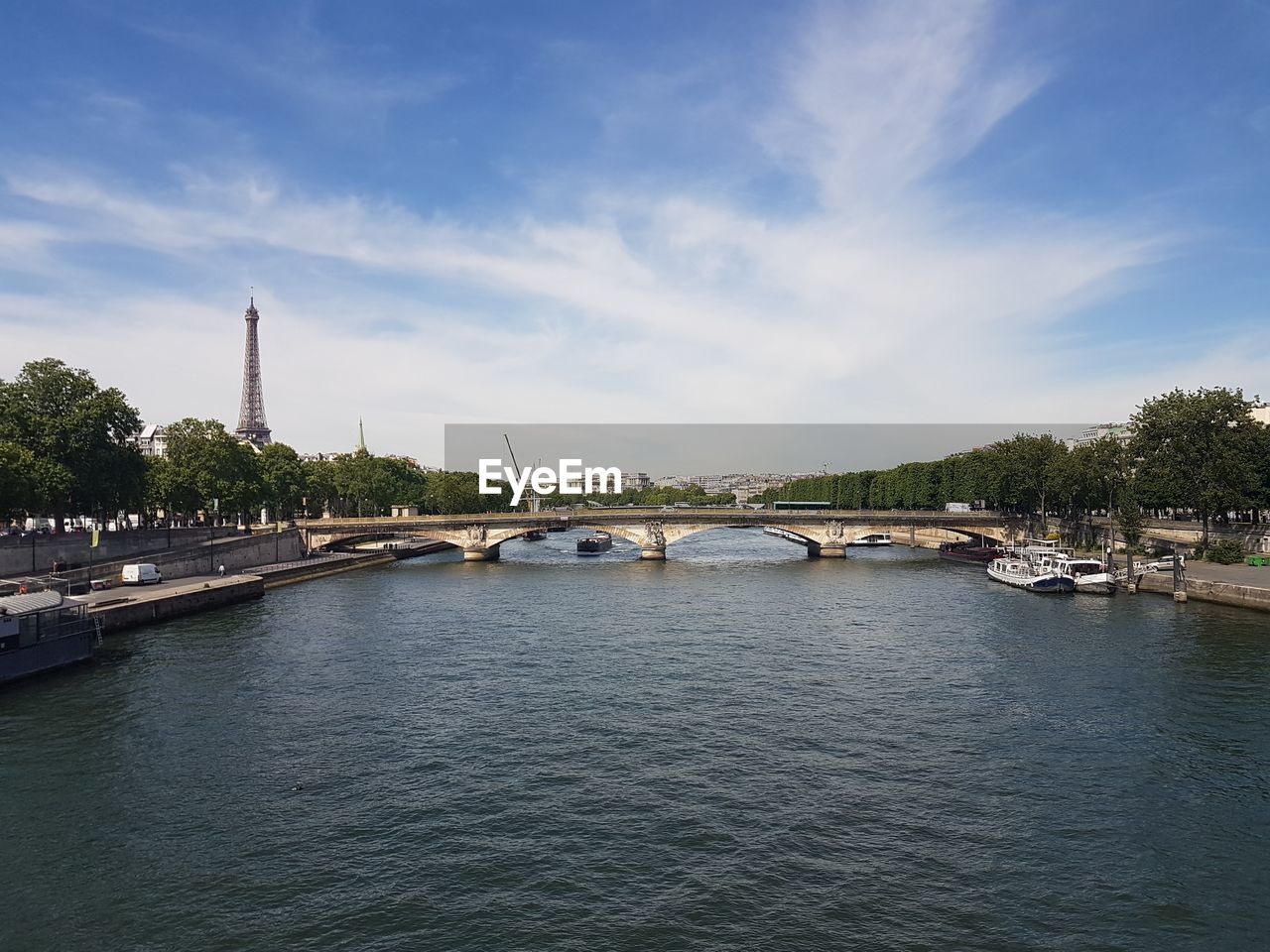 Arch bridge over river against sky in city