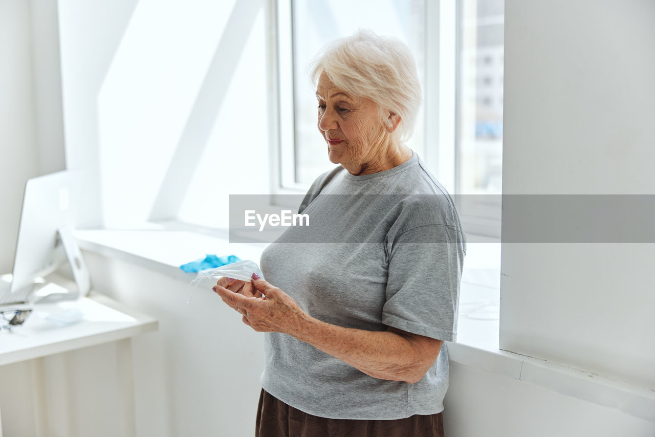 Senior woman standing by window