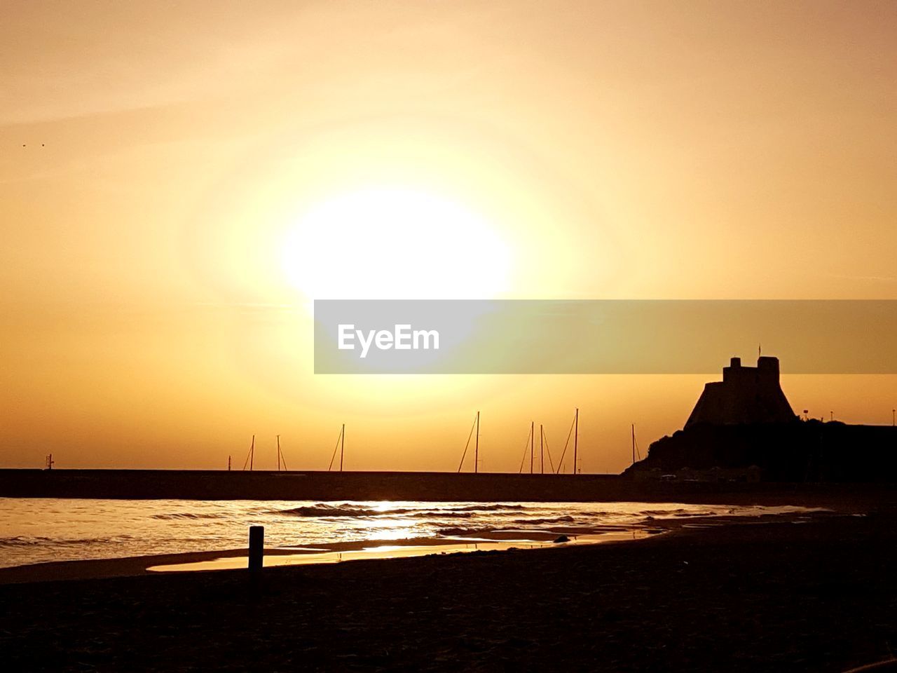 SCENIC VIEW OF CALM SEA AGAINST ORANGE SKY