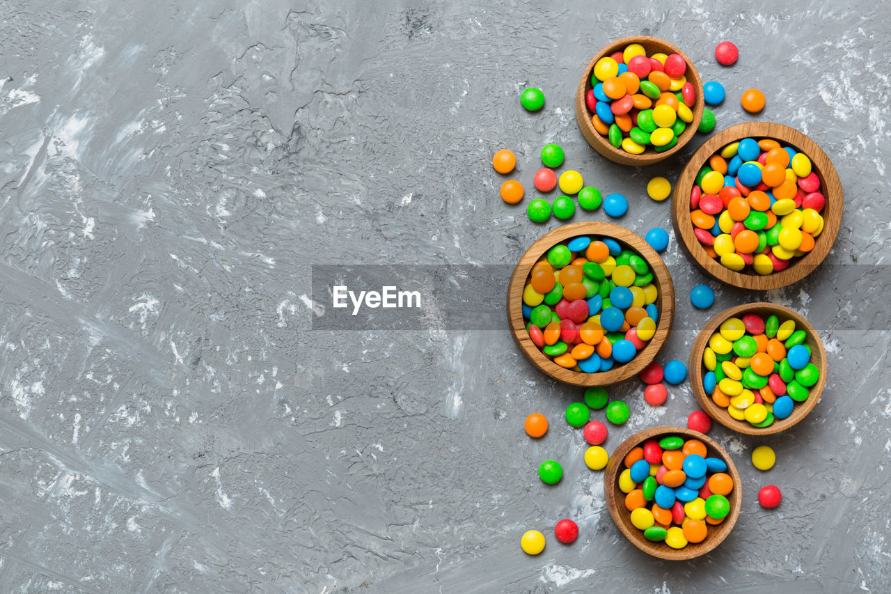 multi colored, sweet food, food and drink, sweet, food, dessert, variation, candy, high angle view, no people, confectionery, still life, large group of objects, indoors, freshness, directly above, sprinkles, baked, unhealthy eating, studio shot, gray, snack, gray background, copy space, chocolate, temptation