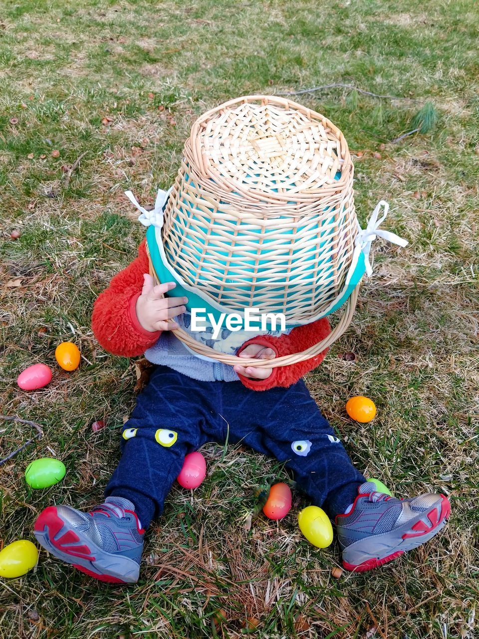 Toddler playing with basket during easter egg hunt