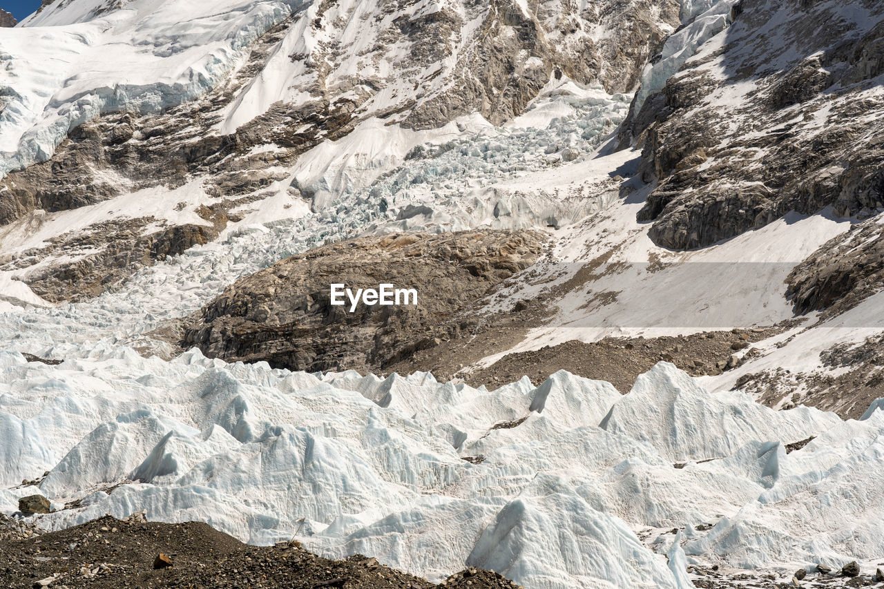 low section of man standing on snowcapped mountain