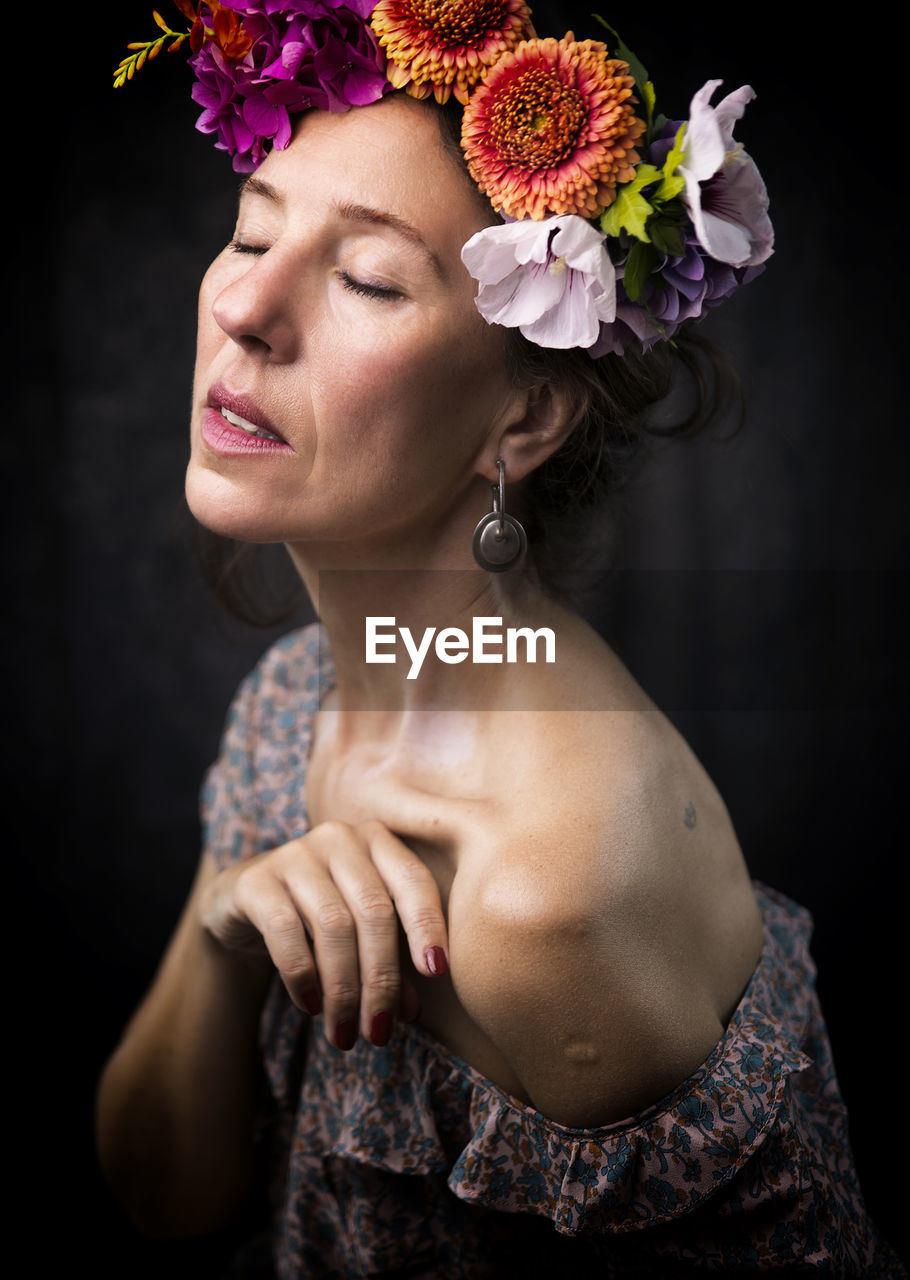 Woman with flowers on her head recalling the style of frida iii