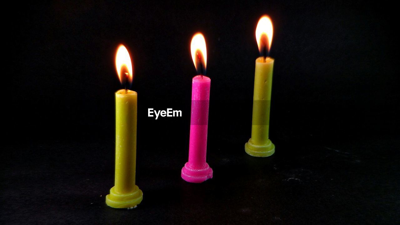 CLOSE-UP OF LIT CANDLES