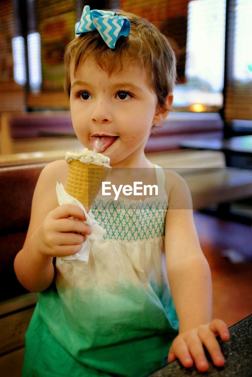 Close-up of girl eating ice cream at restaurant