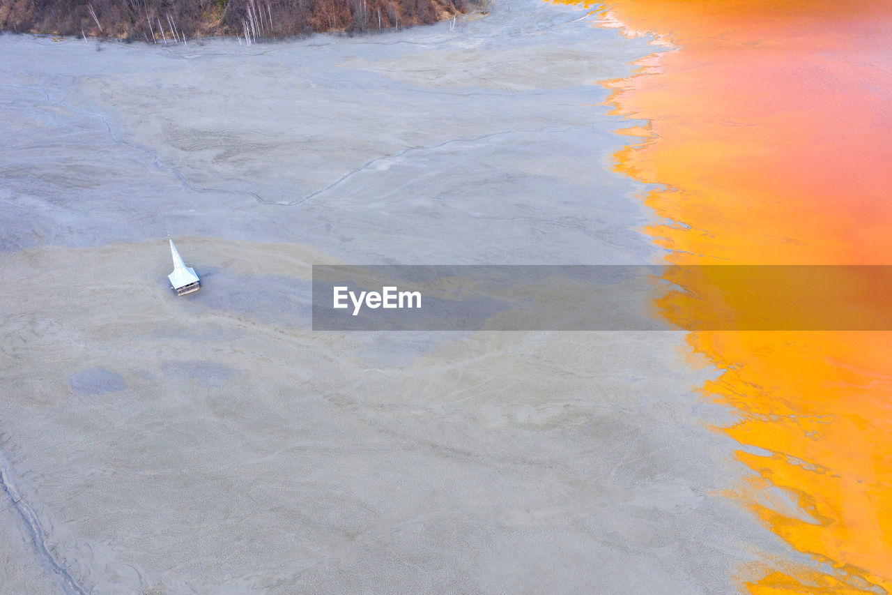 Aerial drone view of a flooded, submerged church in the middle of a contaminated lake, geamana, 