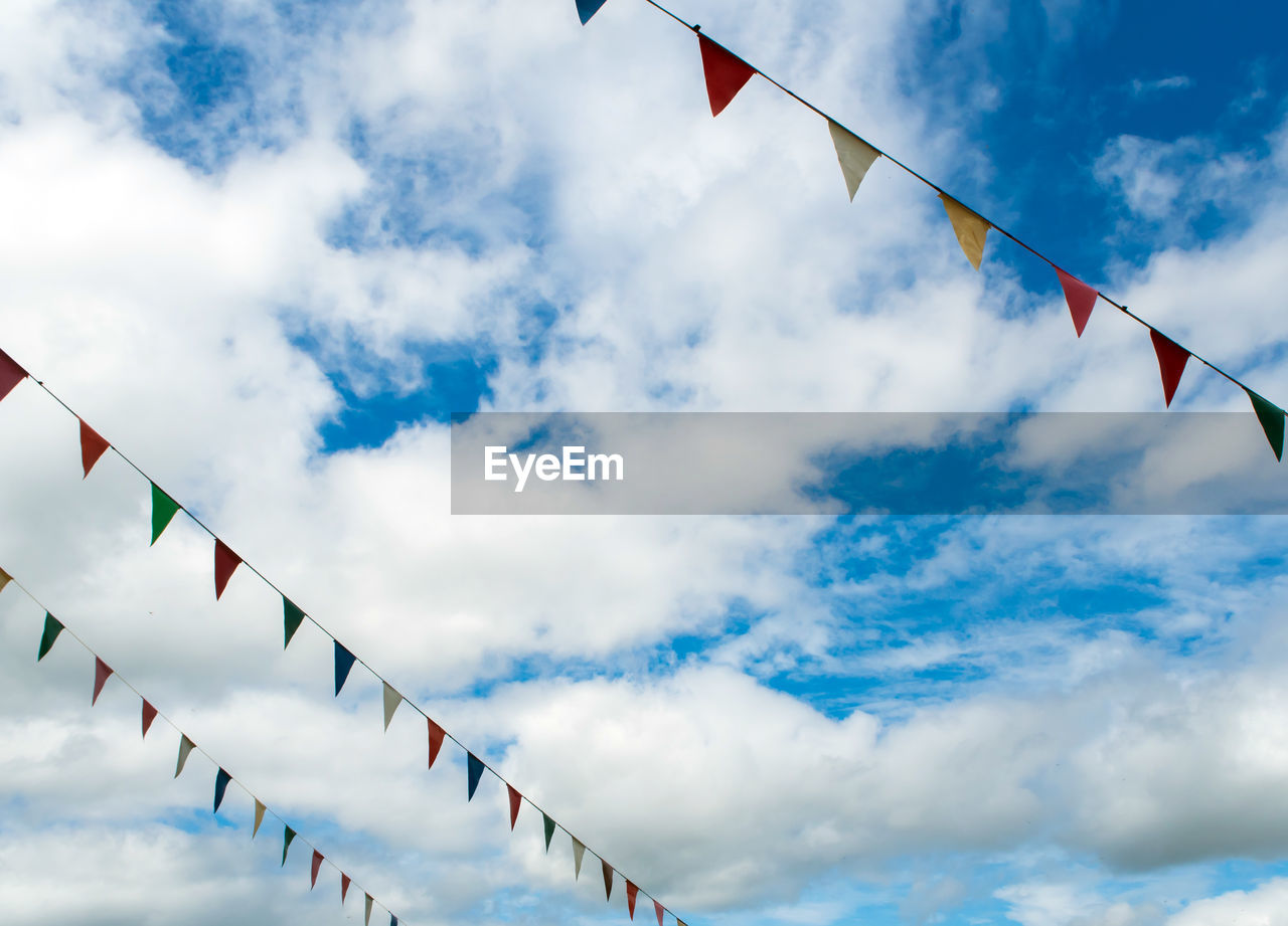 Multi-color triangle flag hanging on the rope and blue sky