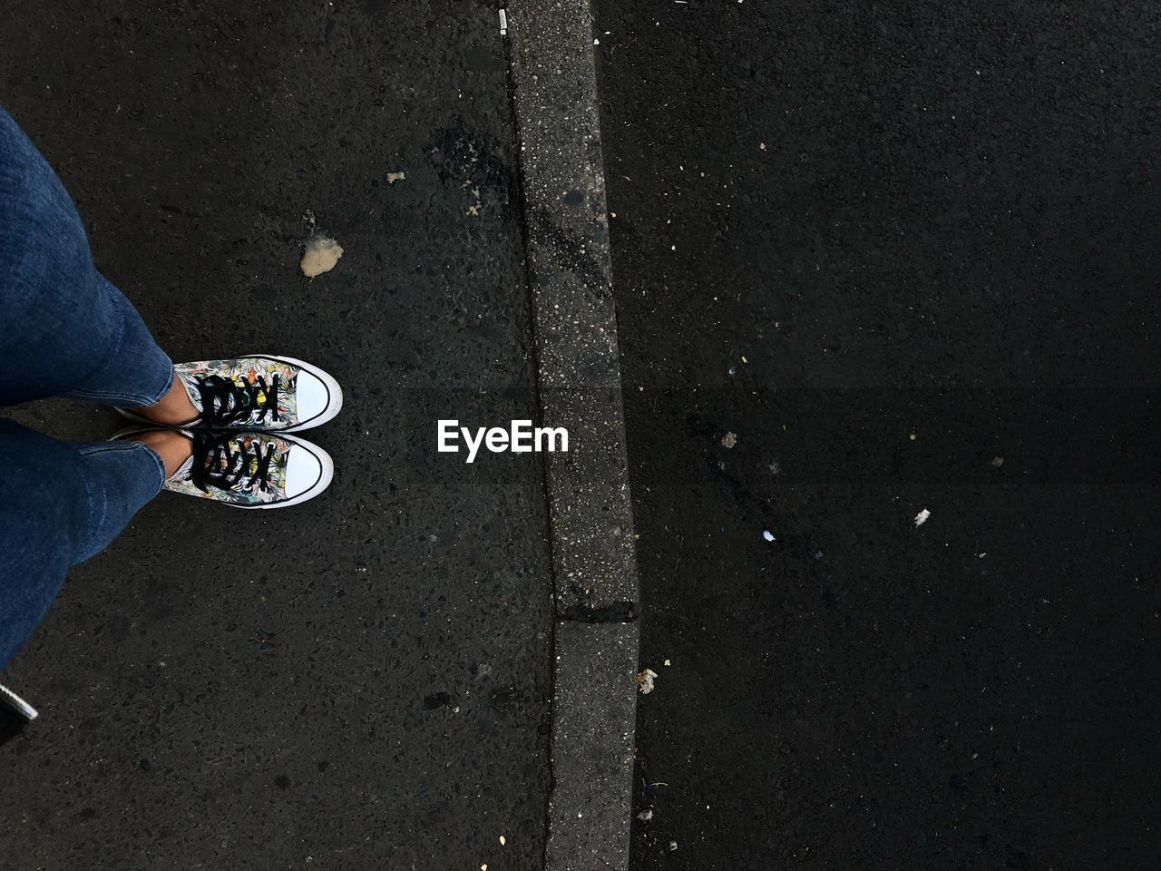 Low section of woman standing on sidewalk