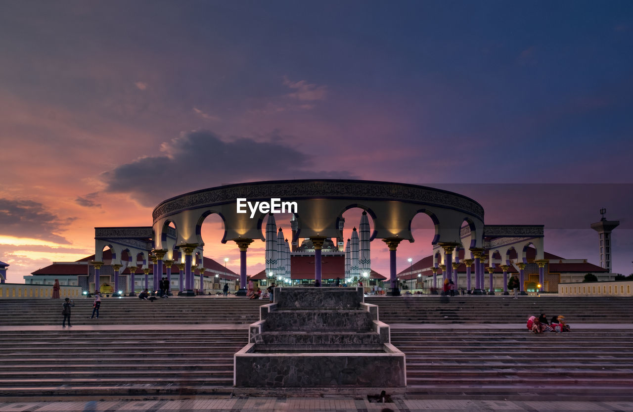 VIEW OF HISTORIC BUILDING AGAINST CLOUDY SKY AT SUNSET