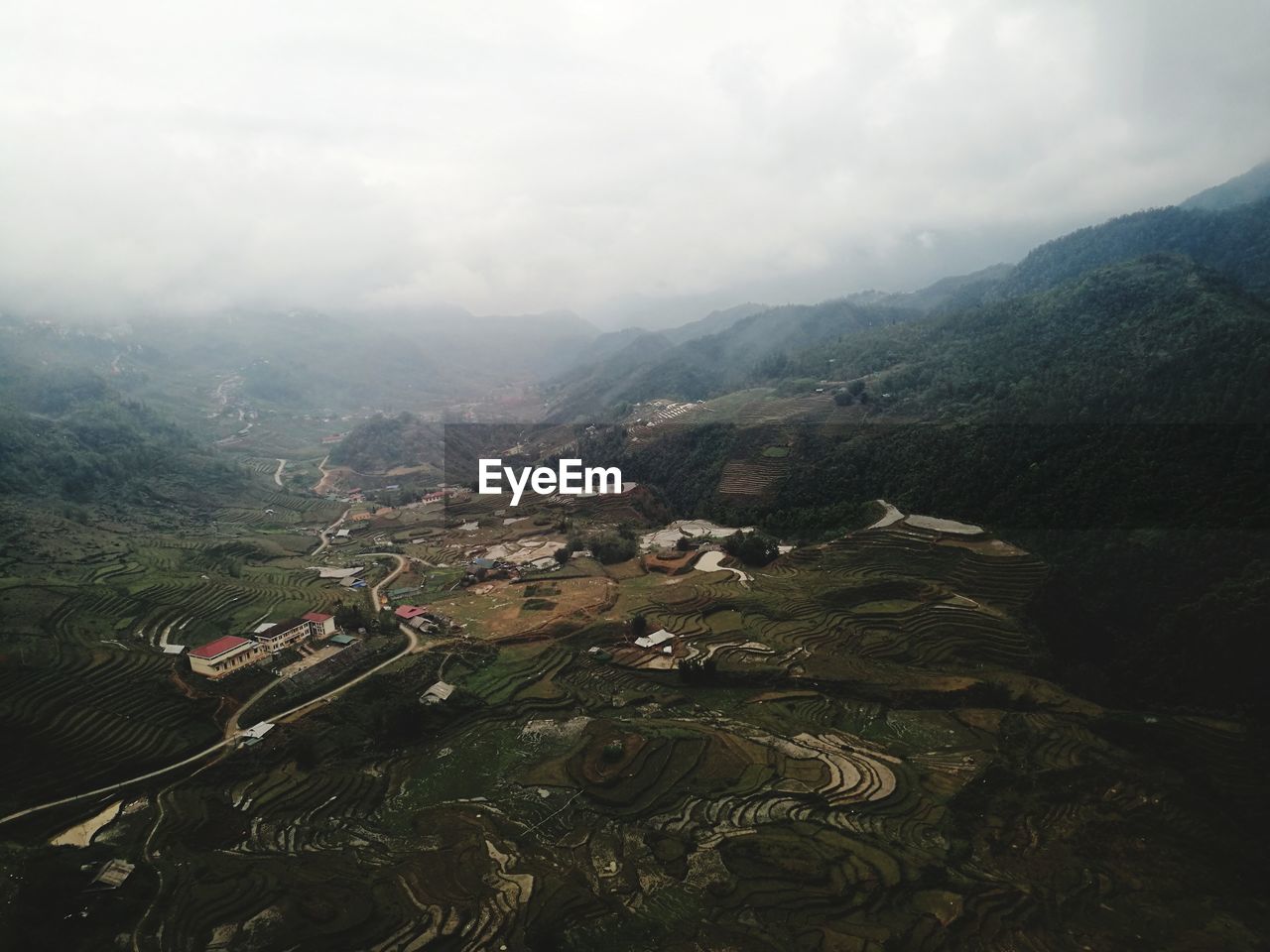 HIGH ANGLE VIEW OF GREEN LANDSCAPE AGAINST SKY