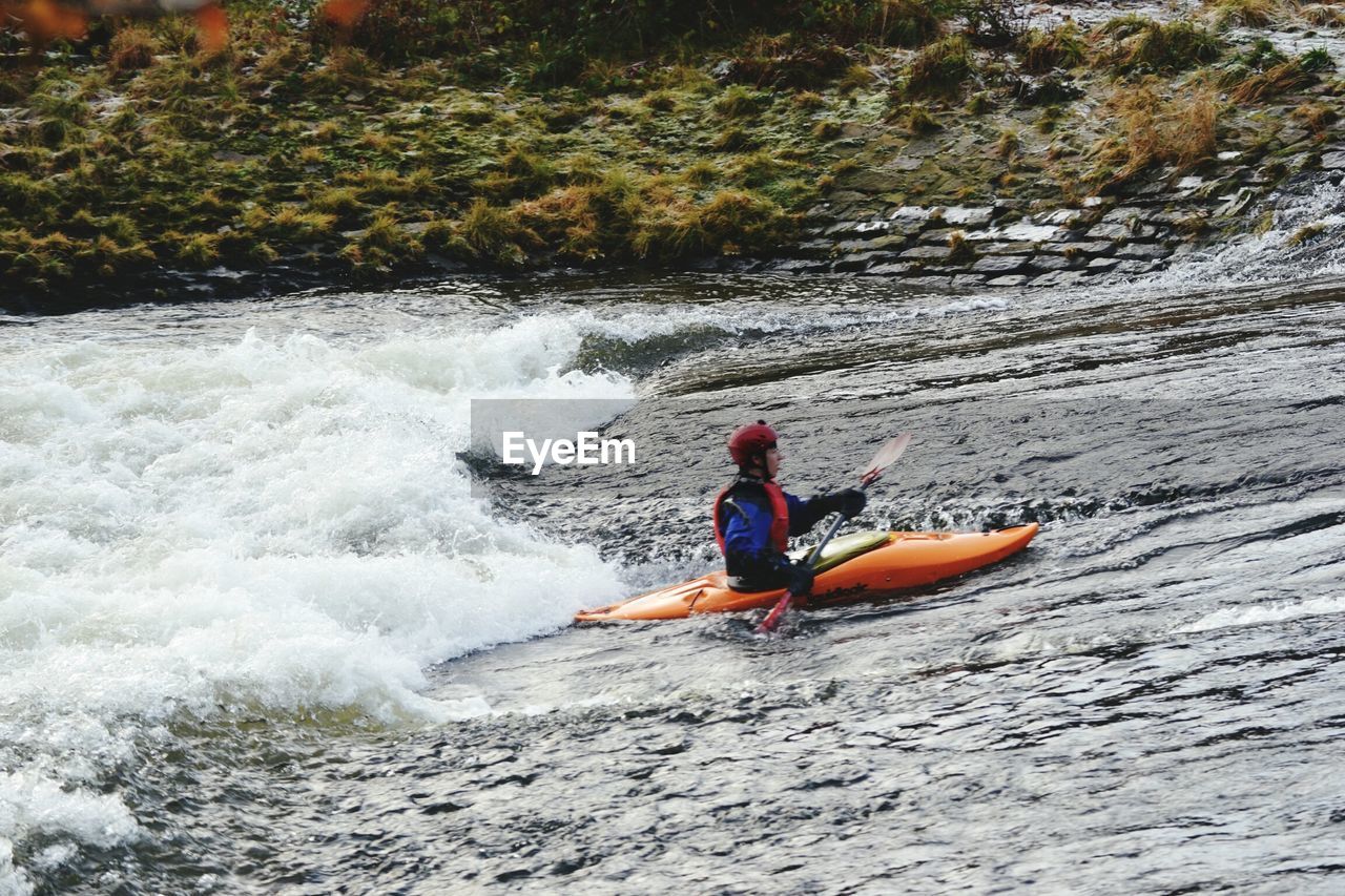 MAN SURFING IN BOAT AT RIVER