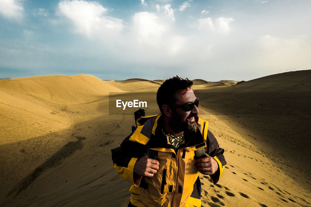 Man standing at desert against sky