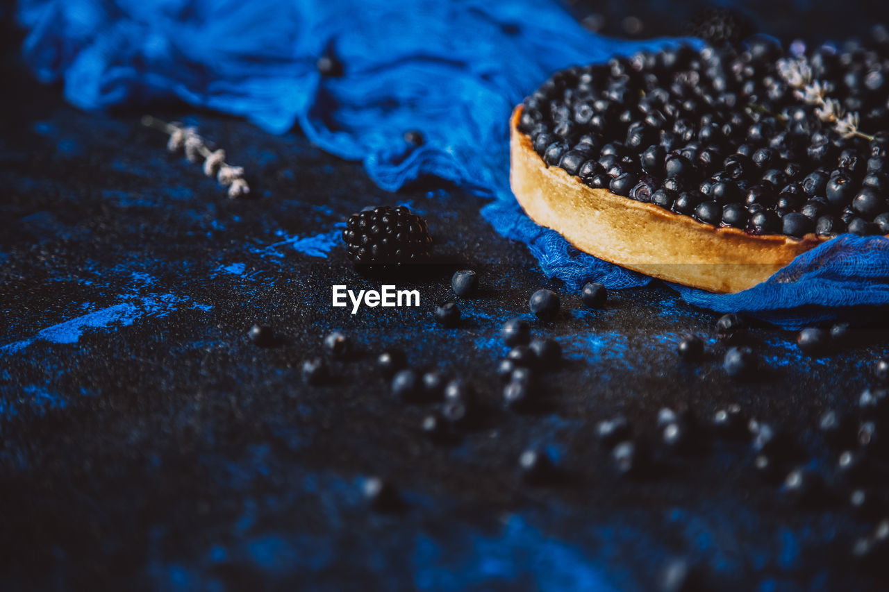 HIGH ANGLE VIEW OF BLACK COFFEE ON BLUE SURFACE