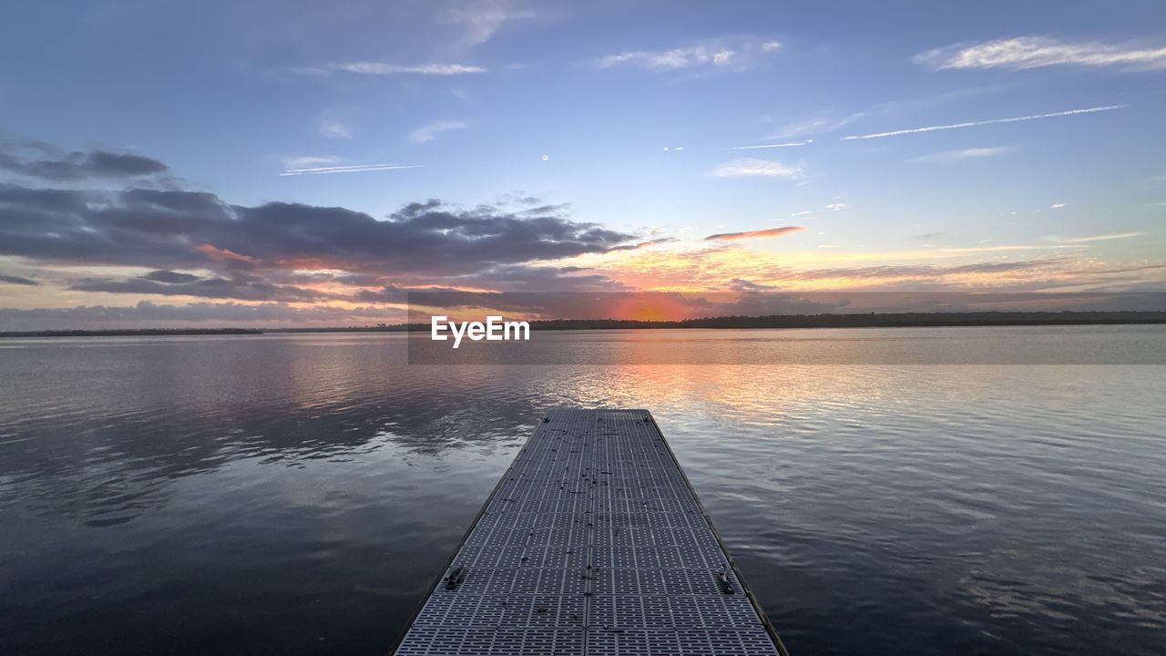 water, sky, horizon, sea, sunset, cloud, reflection, beauty in nature, scenics - nature, nature, dawn, ocean, tranquility, shore, environment, landscape, tranquil scene, sunlight, coast, sun, pier, evening, beach, horizon over water, travel, dramatic sky, outdoors, no people, land, idyllic, travel destinations, blue, bay, seascape, wood, jetty, urban skyline, cloudscape, wave, transportation, nautical vessel, twilight, vehicle, trip, vacation, summer, holiday, architecture, lagoon, relaxation
