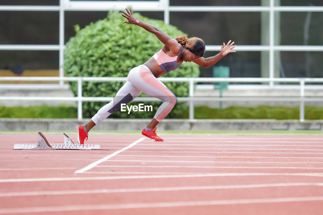 Determinant female athlete running on runner track