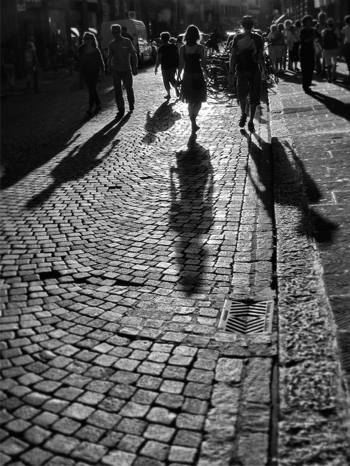 WOMAN WALKING ON FOOTPATH IN CITY