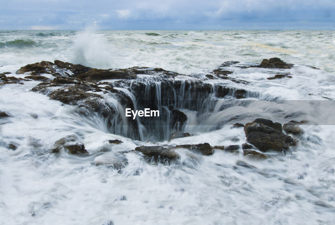 View of sea waves splashing on rock formations