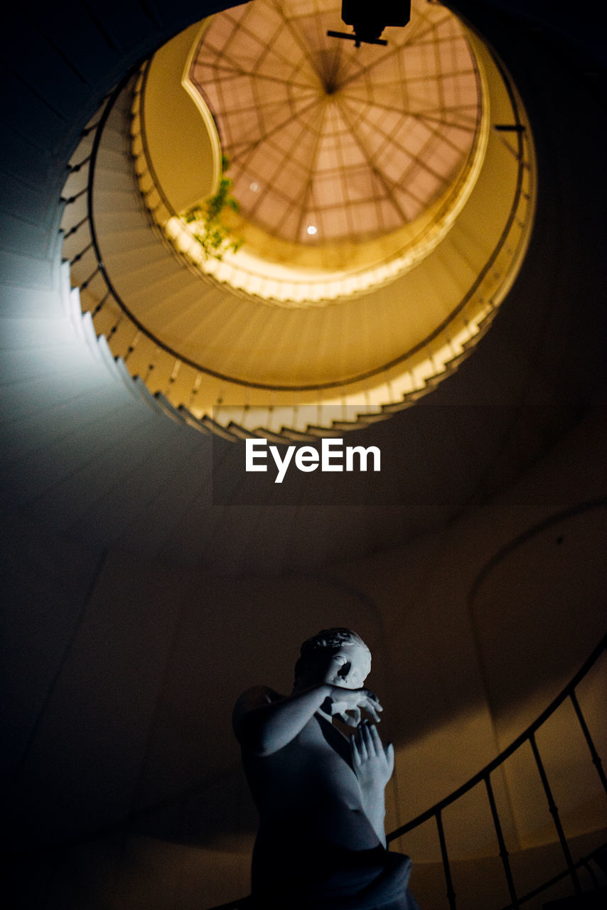 LOW ANGLE VIEW OF STATUE AGAINST ILLUMINATED LIGHT