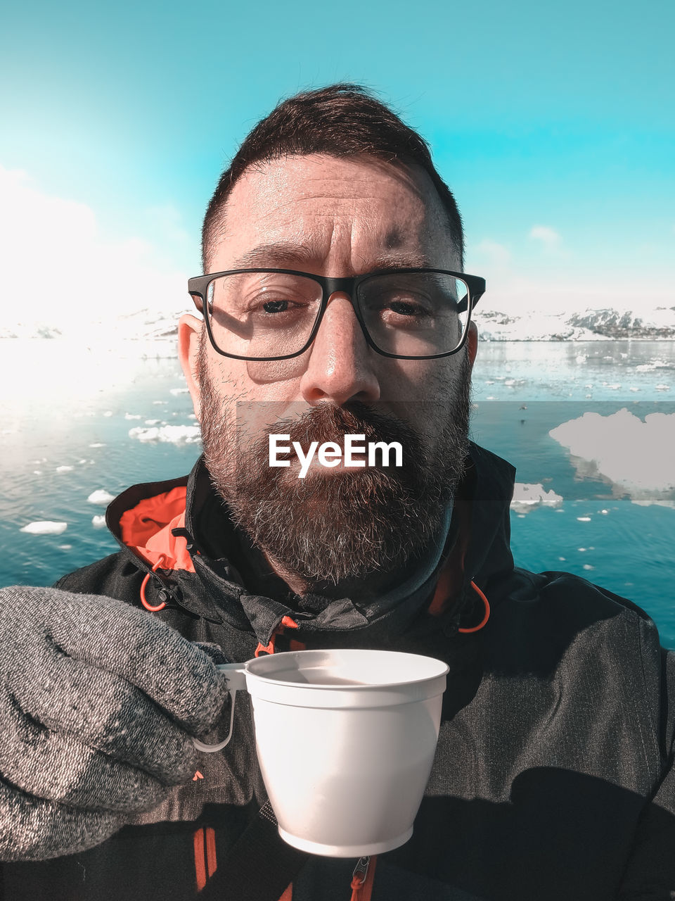 adult, one person, men, glasses, portrait, water, beard, facial hair, eyeglasses, nature, sky, drink, sea, food and drink, refreshment, person, headshot, cold temperature, front view, mature adult, drinking, leisure activity, looking at camera, human face, cup, coffee, lifestyles, winter, clothing, emotion, sunlight, outdoors, relaxation