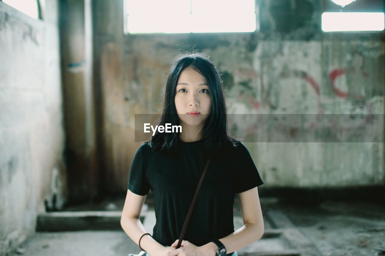 Portrait of beautiful woman standing in abandoned building