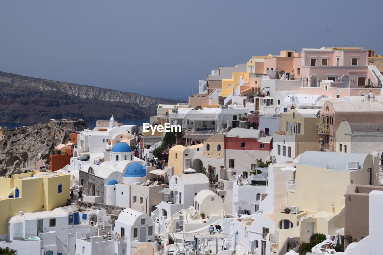 Buildings in city against clear blue sky