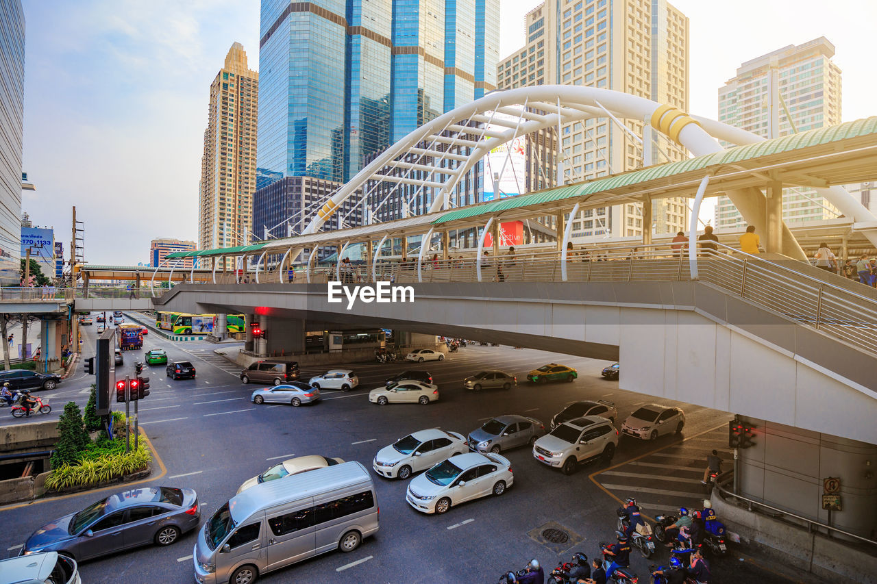 Cars on road by modern buildings in city