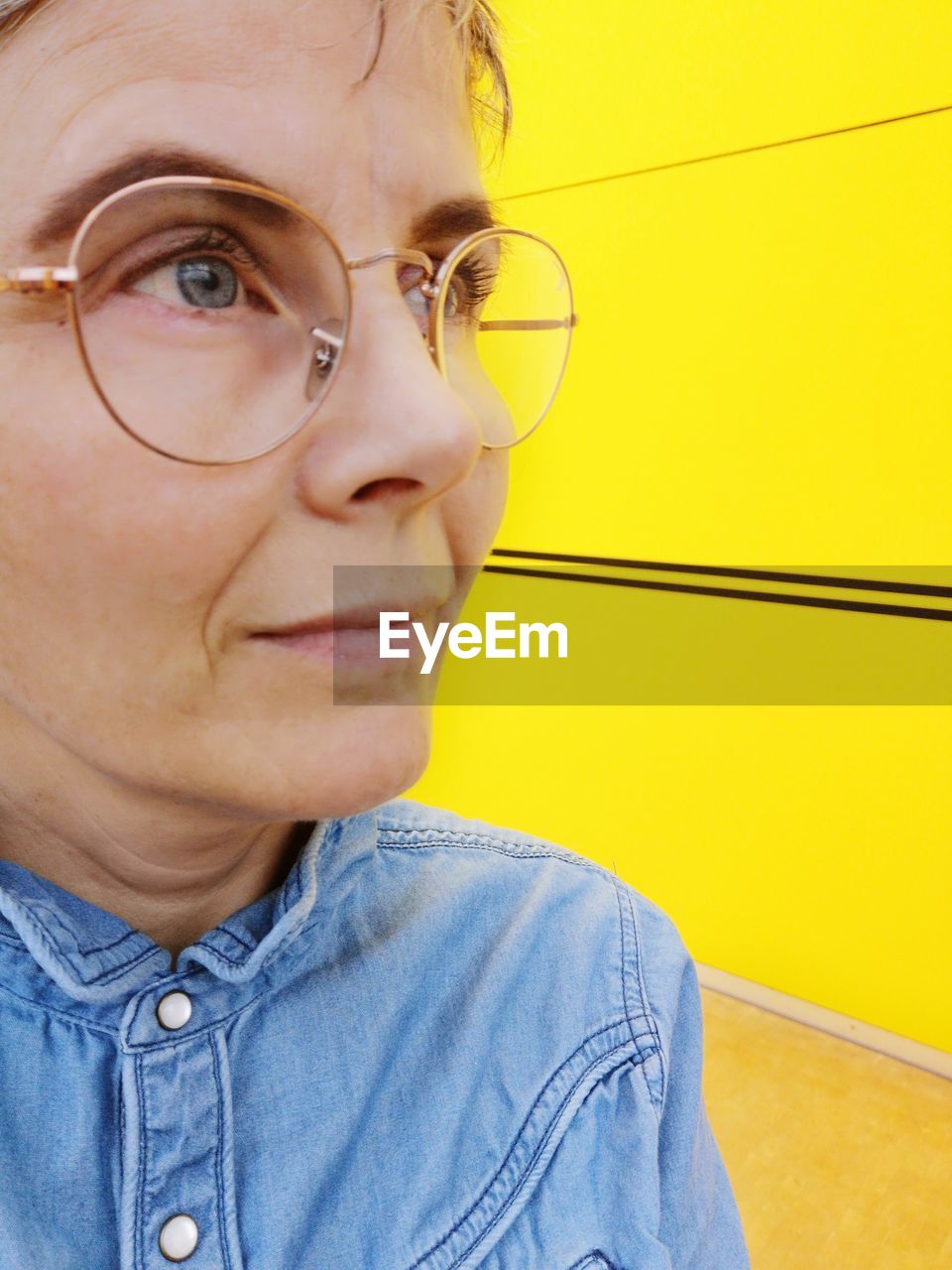 Close-up of thoughtful mature woman looking away while wearing eyeglasses