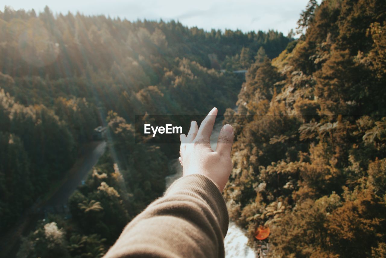 View of human hand against mountain landscape