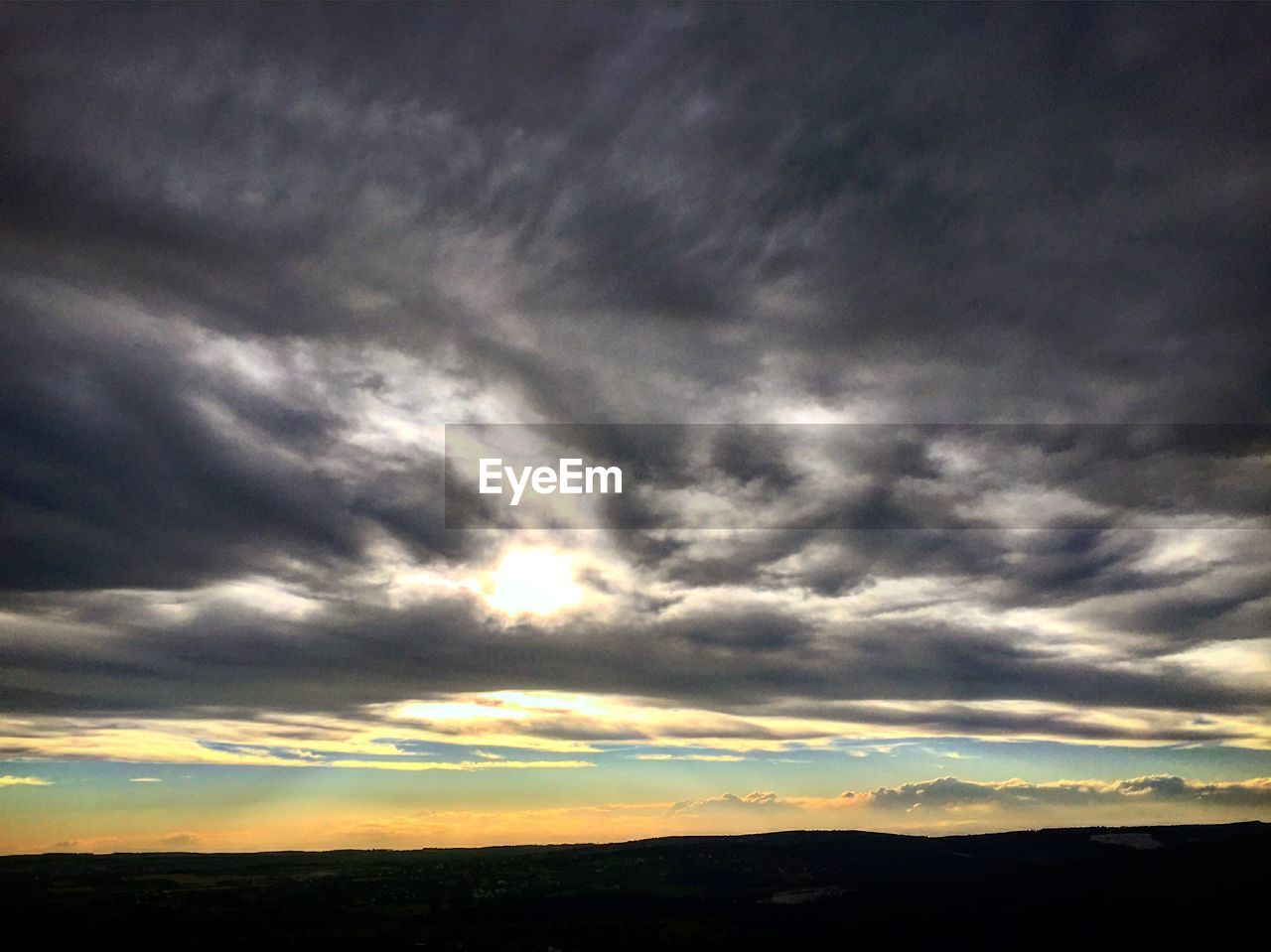 SILHOUETTE OF LANDSCAPE AGAINST DRAMATIC SKY