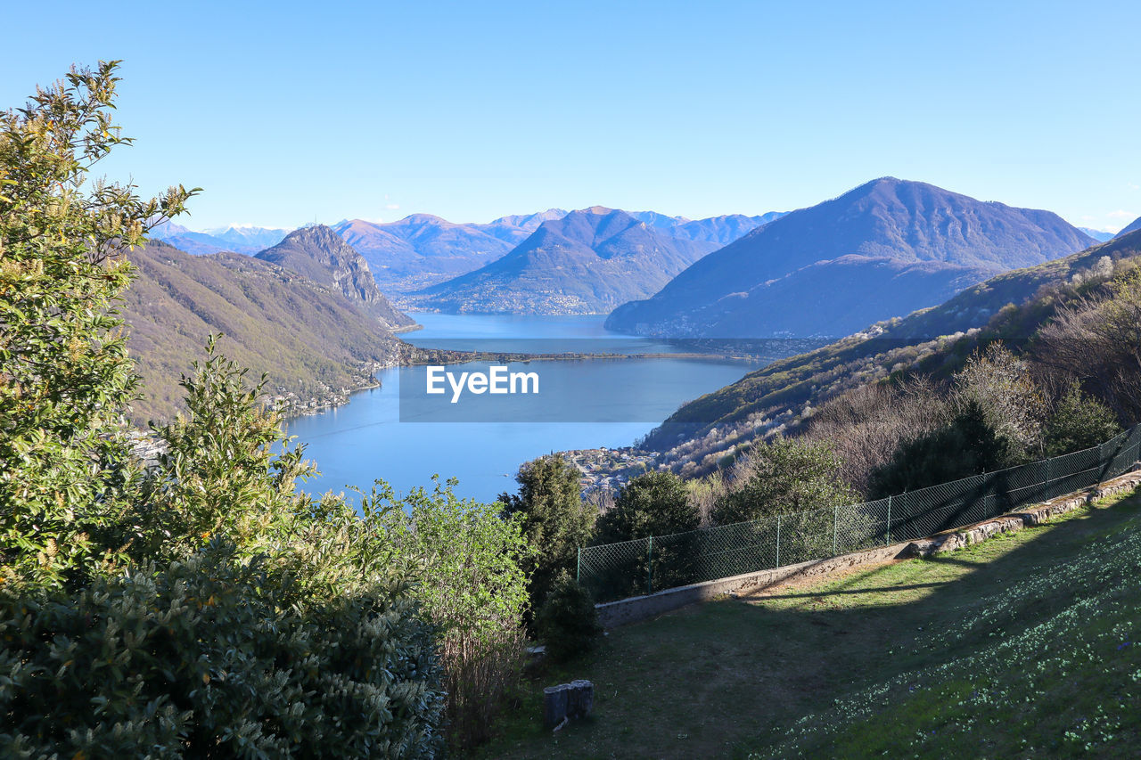 mountain, scenics - nature, beauty in nature, sky, plant, environment, water, nature, landscape, lake, tree, mountain range, blue, tranquility, tranquil scene, clear sky, land, wilderness, no people, travel destinations, travel, reservoir, day, non-urban scene, ridge, outdoors, sunny, mountain pass, pine tree, coniferous tree, pinaceae, sunlight, tourism, walking, idyllic, valley, forest