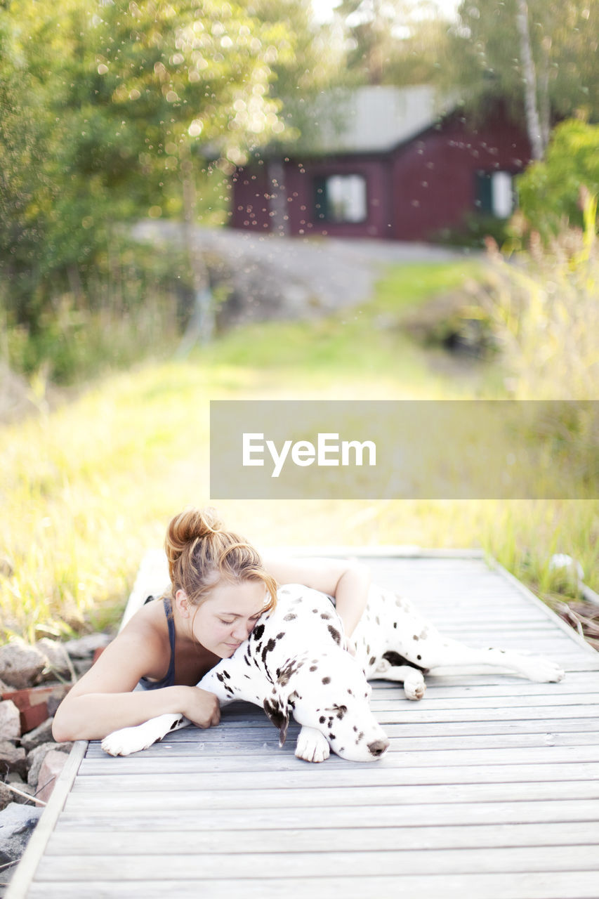 Woman with dalmatian dog at jetty