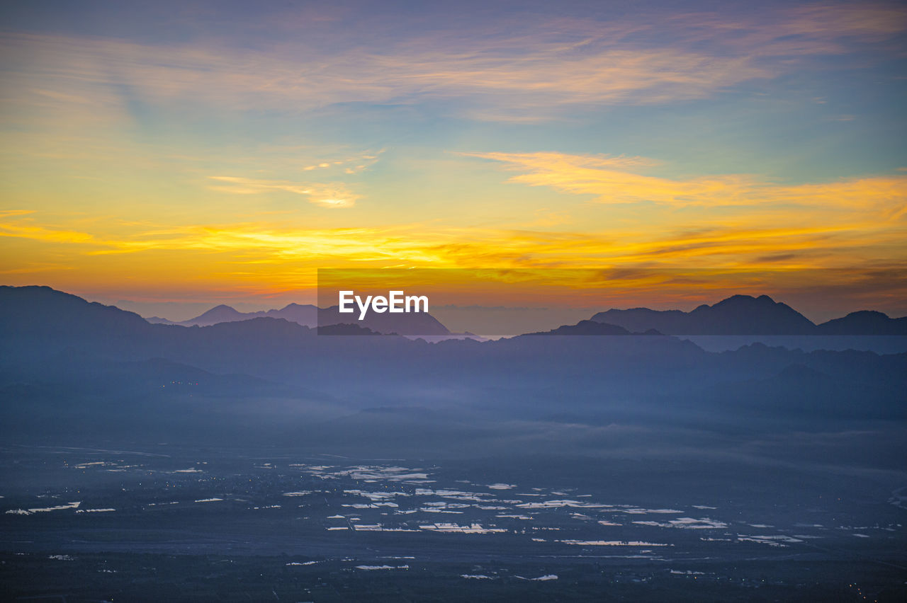 SCENIC VIEW OF SILHOUETTE MOUNTAINS AGAINST DRAMATIC SKY