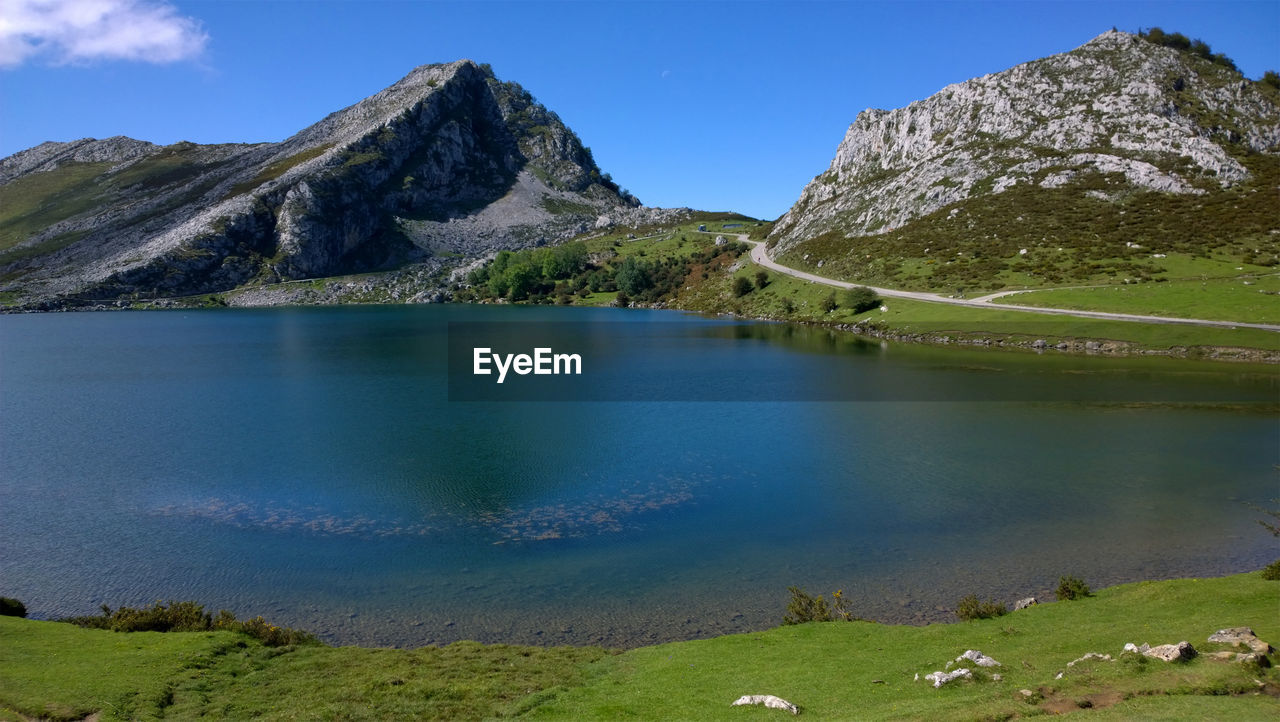 Scenic view of lake and mountains against blue sky