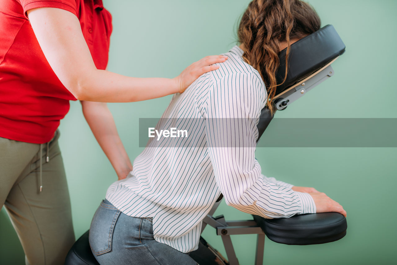 Corporate stress relief chair massage in the office. corporate female employee sitting 