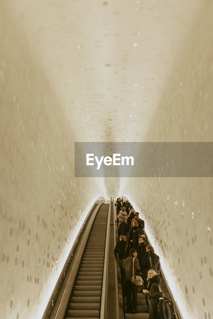 Low angle view of people standing on escalator