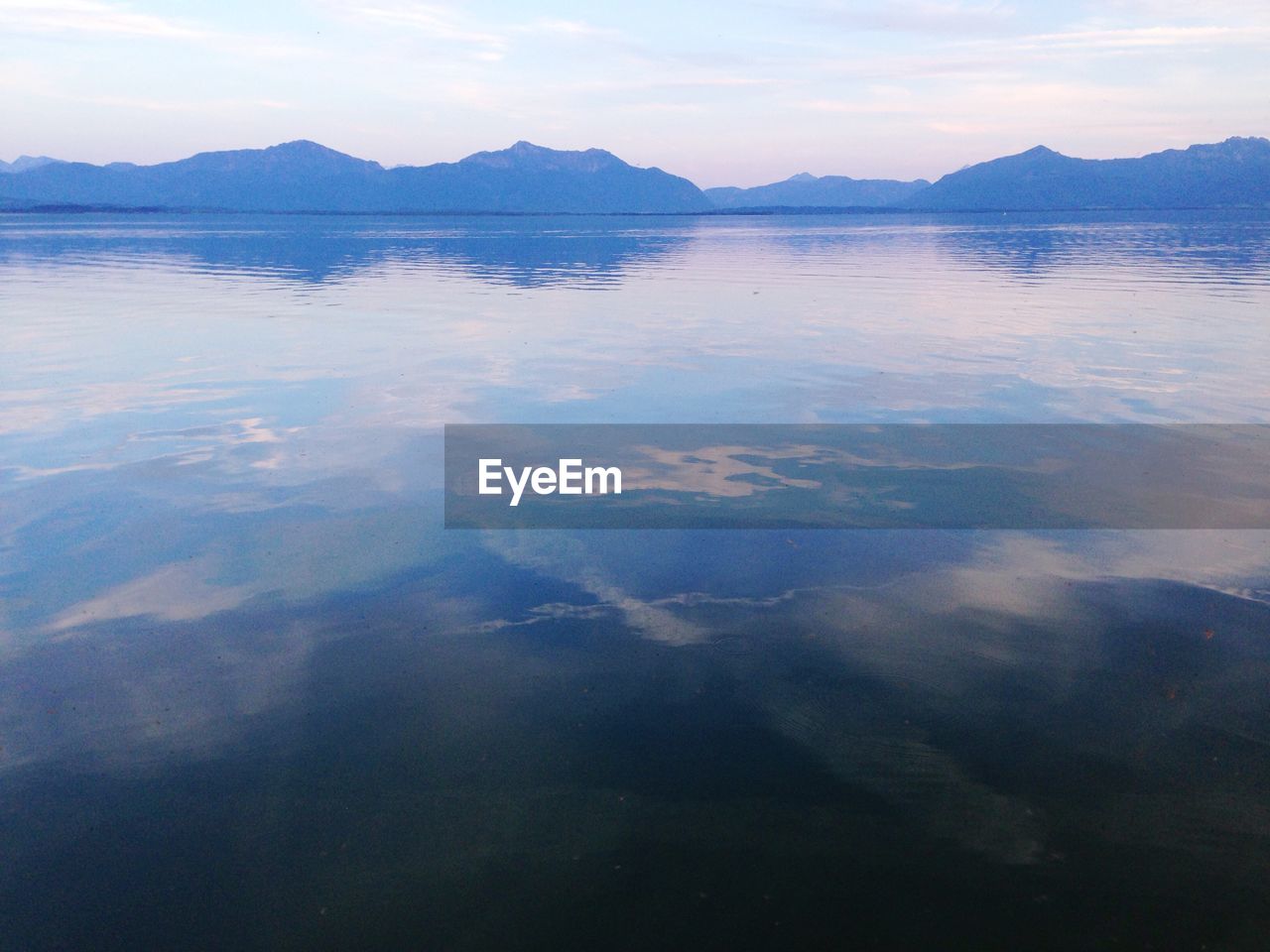 Calm lake with mountains on background