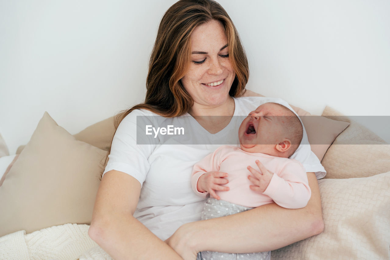 Young caucasian mother with a one-month baby in her arms.