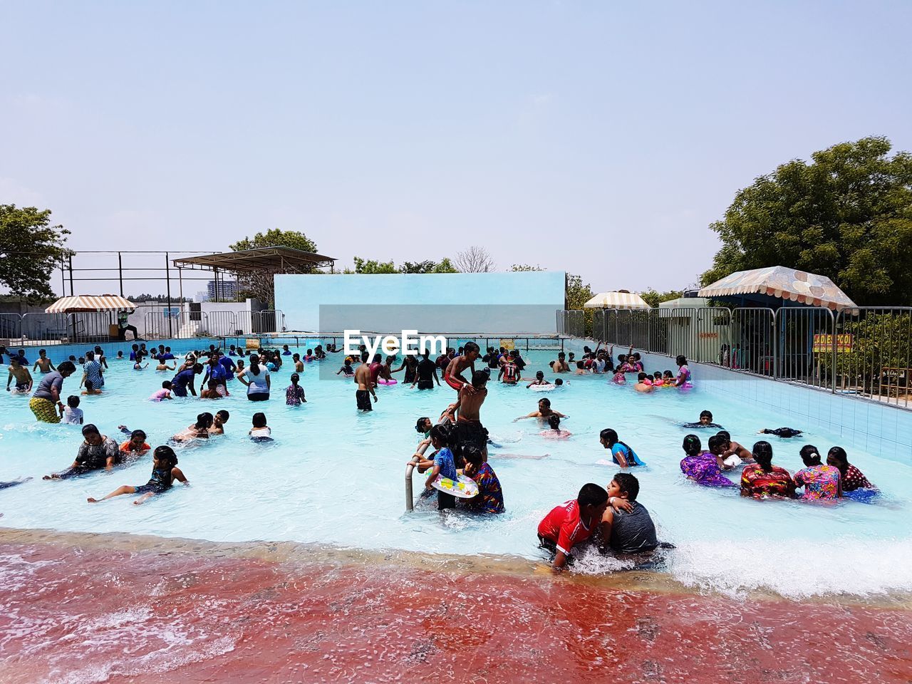 People in swimming pool against clear sky