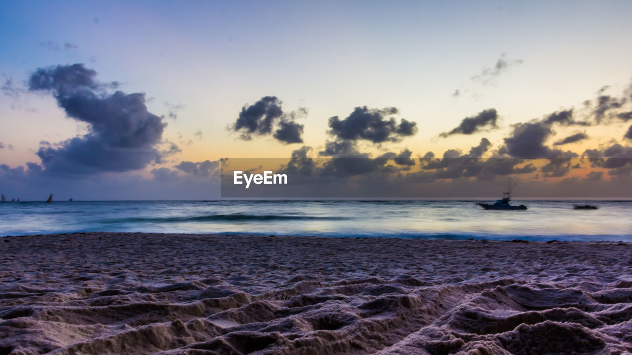 SCENIC VIEW OF BEACH AGAINST SKY DURING SUNSET