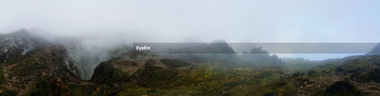 PANORAMIC VIEW OF TREES AND MOUNTAINS AGAINST SKY